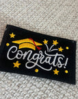Embroidered patch with 'Congrats!' text and graduation cap design on a textured fabric background