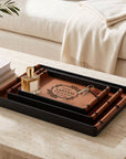 Set of three brown leatherette trays in three sizes on a coffee table