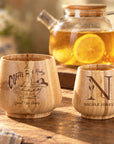 Two personalised engraved bamboo cups in small and large sizes with tea