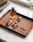 Personalised brown leatherette vanity tray holding a watch, keys and perfume, engraved with a logo