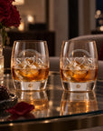 Two personalised bubble tumbler whisky glasses with monograms on a coffee table