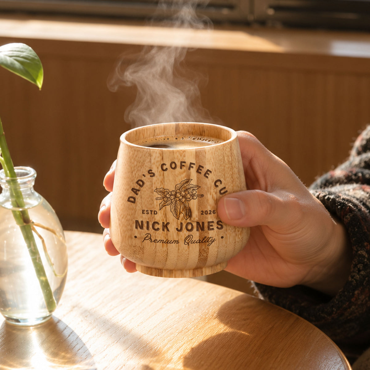 Personalised engraved bamboo coffee cup held with steaming coffee