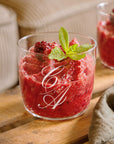 Personalised engraved glass tumbler with a monogram holding a berry dessert