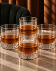 Four personalised patterned-bottom whisky glasses engraved with names