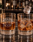 Pair of personalised patterned-bottom whisky tumblers engraved with names on a bar