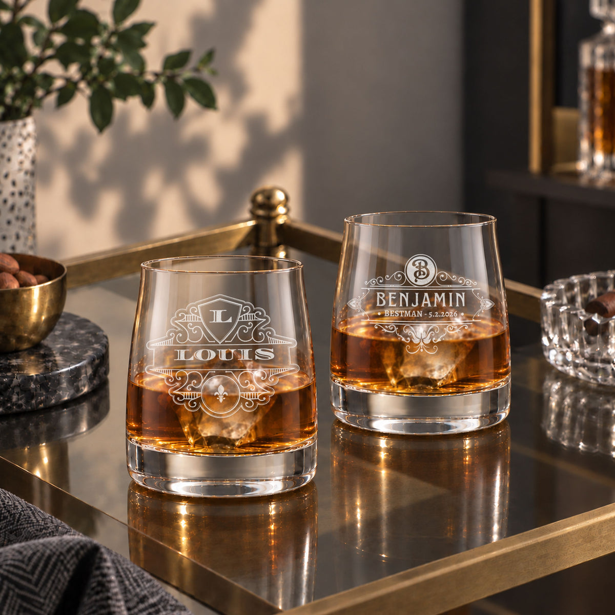 Pair of personalised rocks whisky glasses with monogram designs on a bar cart