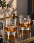 Pair of personalised rocks whisky glasses with monogram designs on a bar cart
