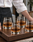Set of four personalised rocks whisky glasses engraved with names on a serving tray