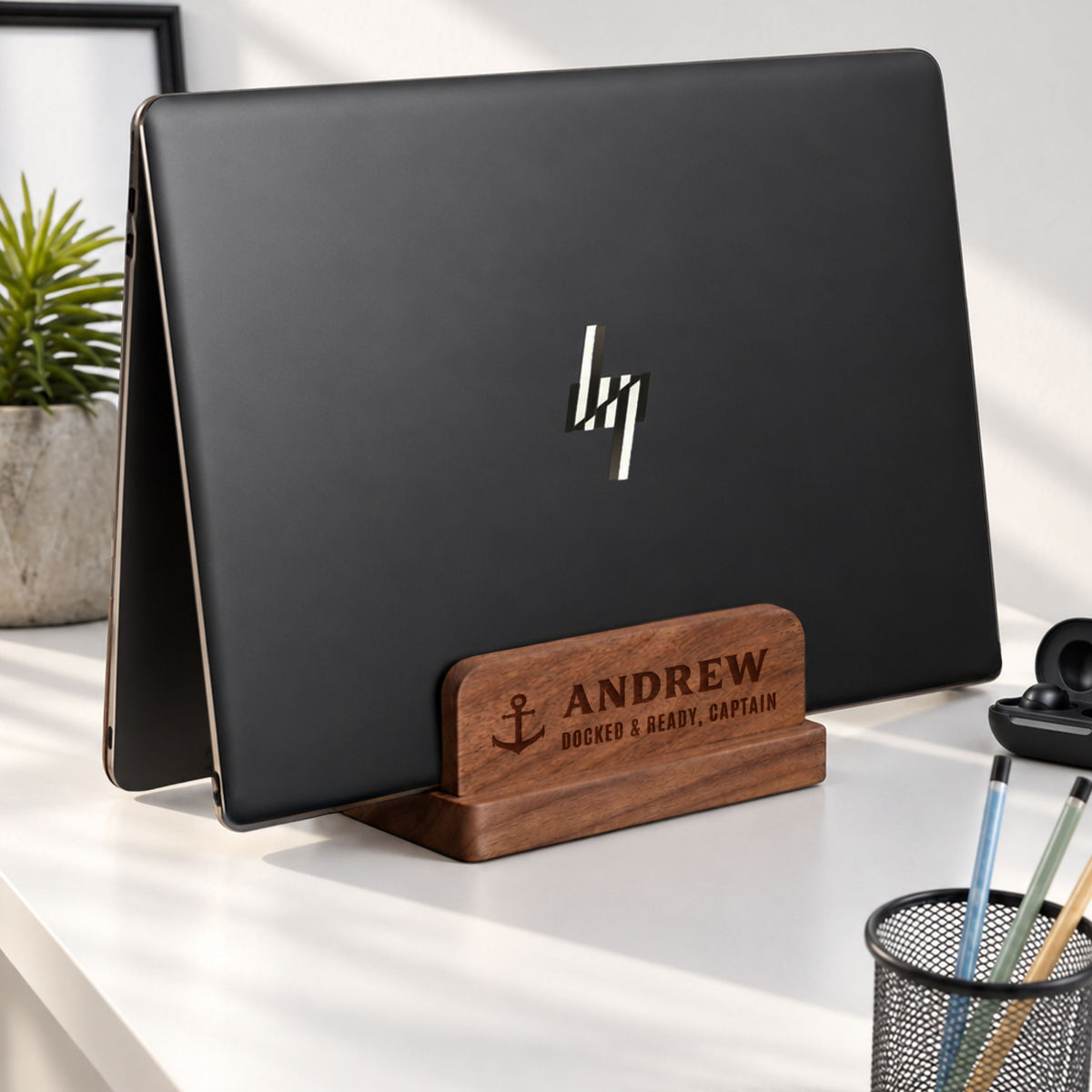 Personalised walnut double-slot laptop stand engraved with a name, holding a laptop