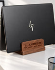 Personalised walnut double-slot laptop stand engraved with a name, holding a laptop