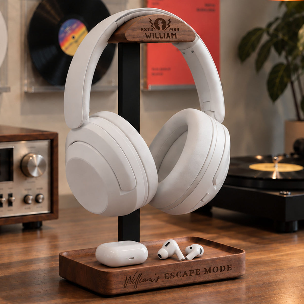Personalised walnut and metal headphone stand with engraved head and storage tray holding AirPods
