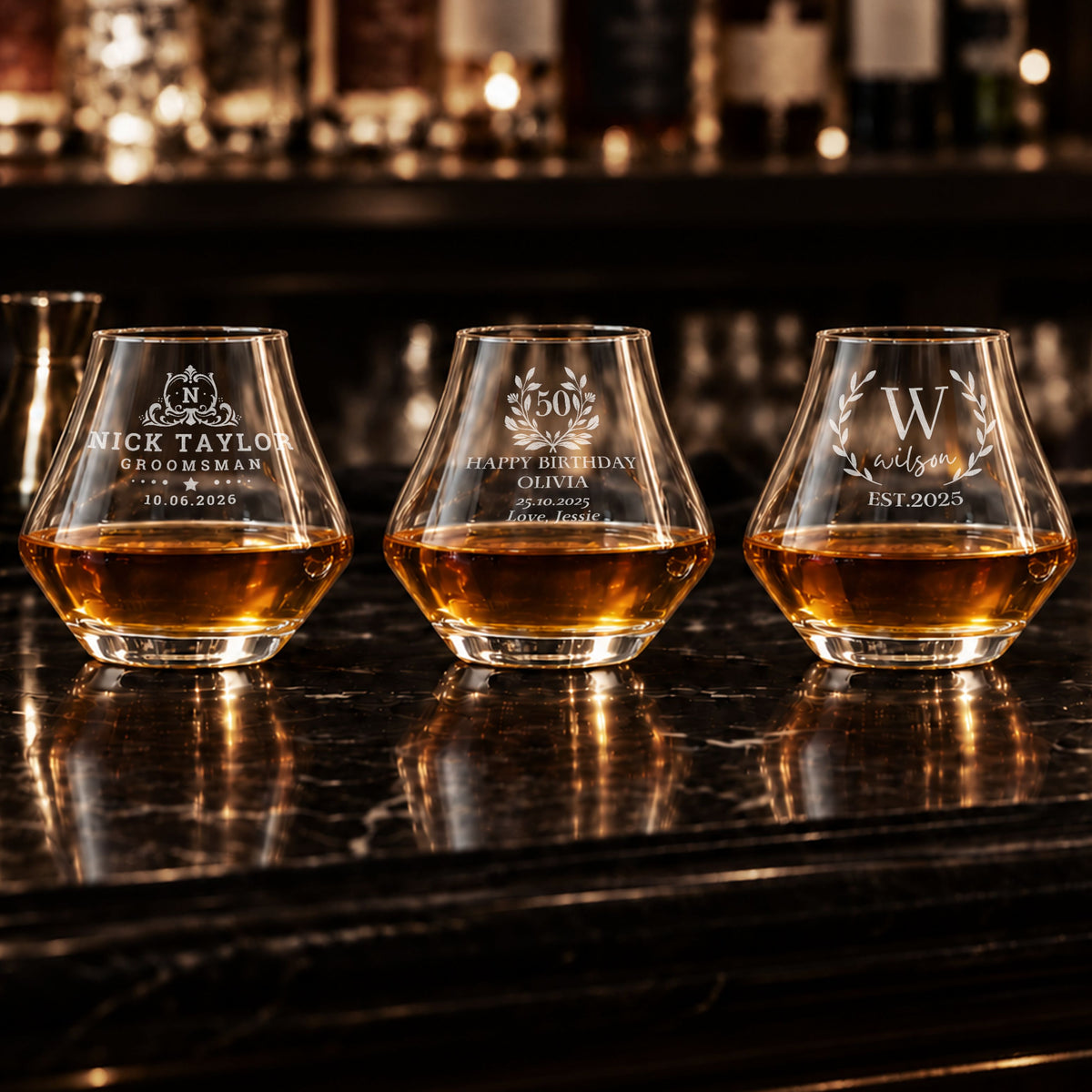 Three personalised engraved whisky tumblers on a bar with whisky