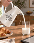 Personalised white enamel jug pouring milk, engraved with a family name