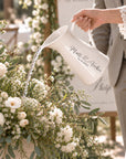 Personalised white enamel jug used as a watering can, engraved for a wedding