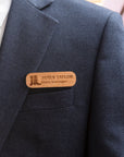 Personalised oval wooden name badge worn on a suit jacket, engraved with a name and title