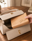 Personalised engraved cherry wood travel jewellery box being placed into a handbag